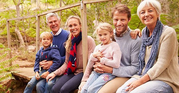 Multi-generation family portrait on a bridge in a forest
