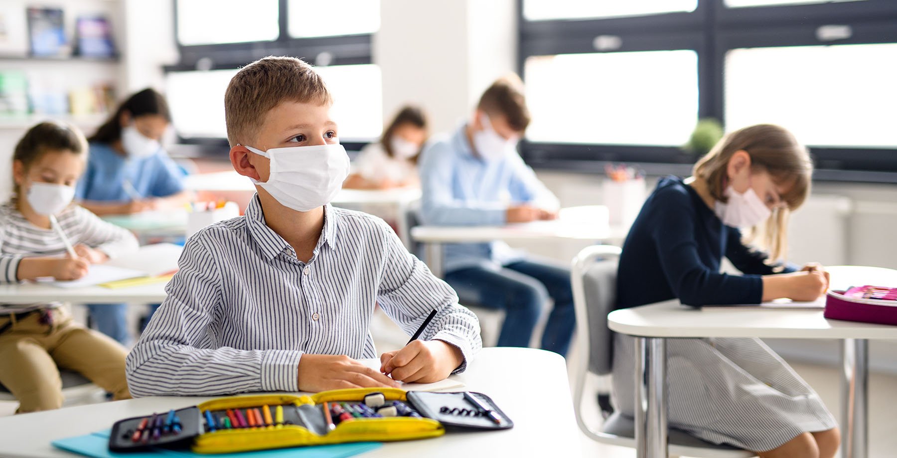 Boy Wearing a Mask at Desk in Classroom